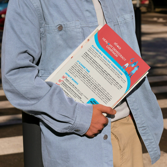 Person holding a stack of papers with Vot-ER's Healthy Democracy Campaign one pager on top