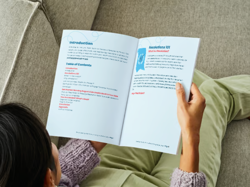 Woman holding a Vot-ER Guide on how to pass a resolution within an association with an interior view.