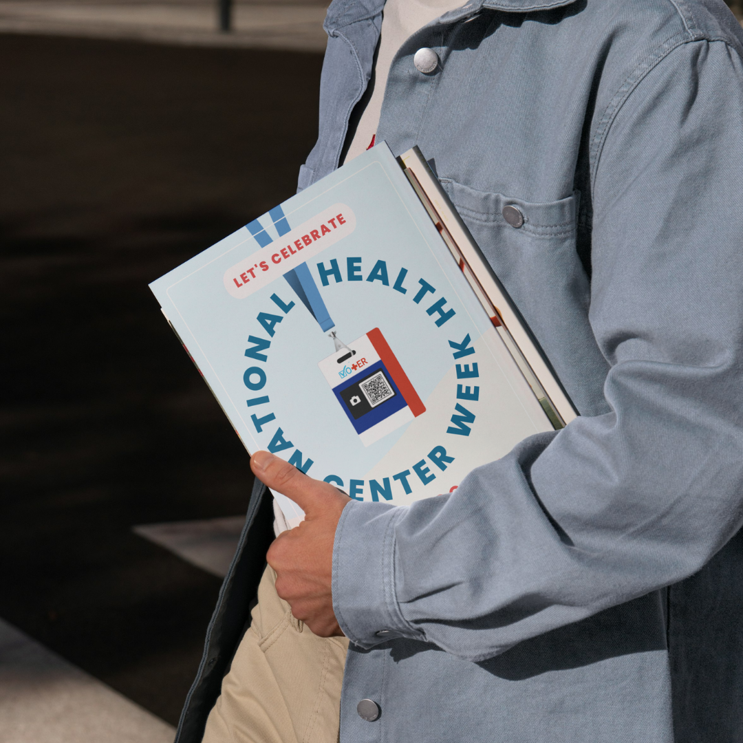 Person holding a printed version of the 'National Health Center Week' toolkit